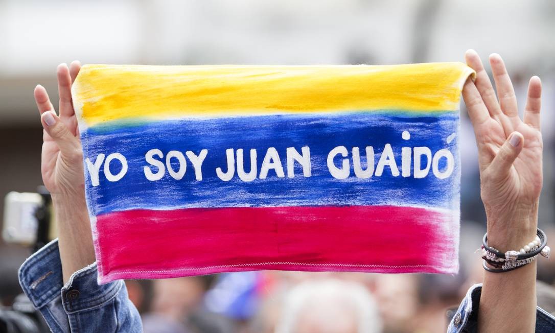 Manifestante carrega bandeira com os dizeres "Eu sou Juan Guaidó". Ainda que muitos países apoiem a legitimidade do presidente-interino, uma série de outros se opõem ao anúncio. Rússia, Turquia, China e Cuba são alguns dos que reforçaram apoio ao atual presidente Nicolas Maduro Getty Images / Getty Images