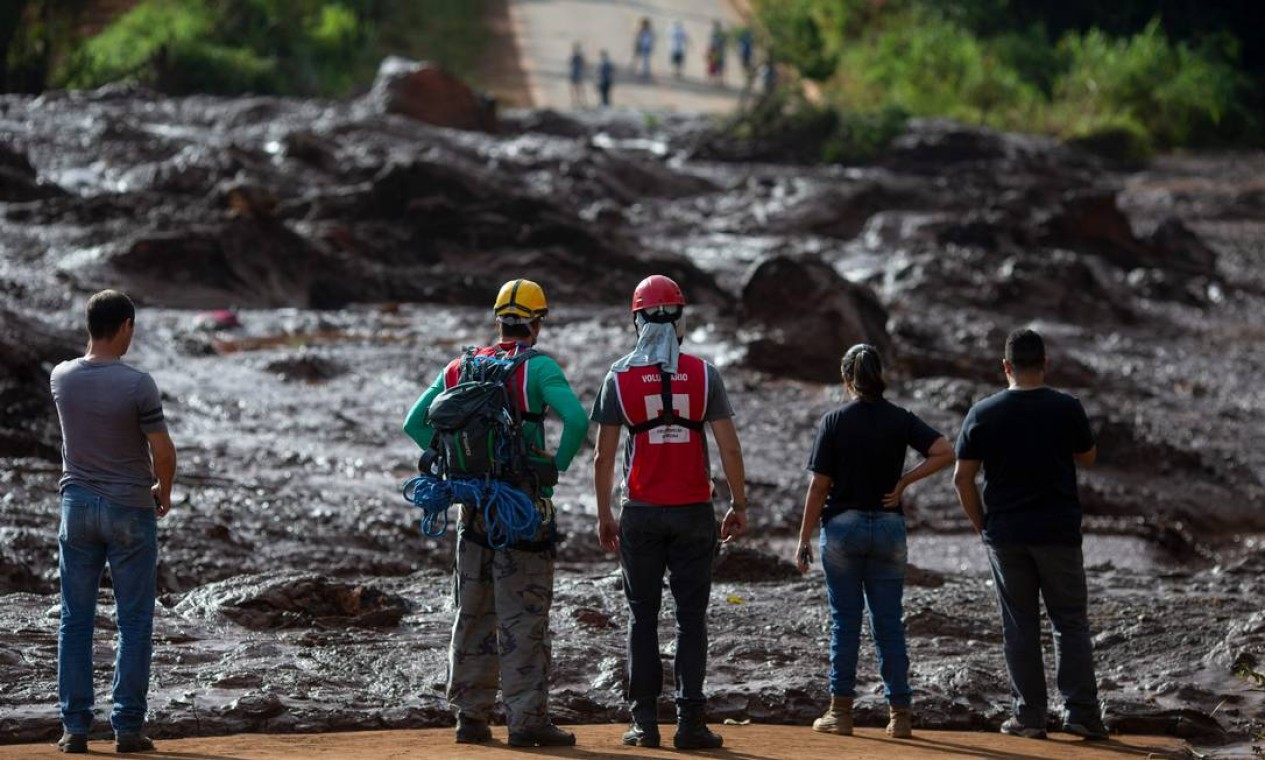 Pessoas da comunidade de Alfredo Torres observa área atingida pela lama após o incidente Foto: Mauro Pimentel / AFP