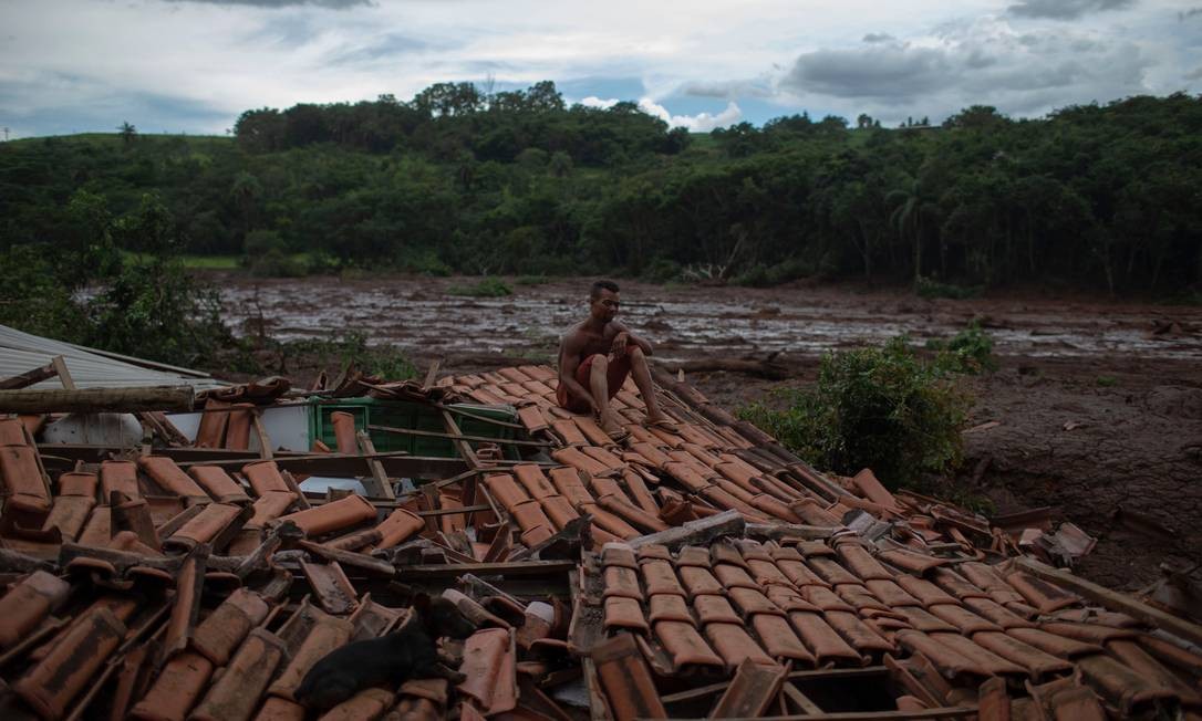 "Tudo estava tremendo e vi enormes árvores e pessoas desaparecendo sob a lama", disse Emerson dos Santos, sentado no telhado da casa de sua família para proteger o que restou de seus pertences de saqueadores MAURO PIMENTEL / AFP