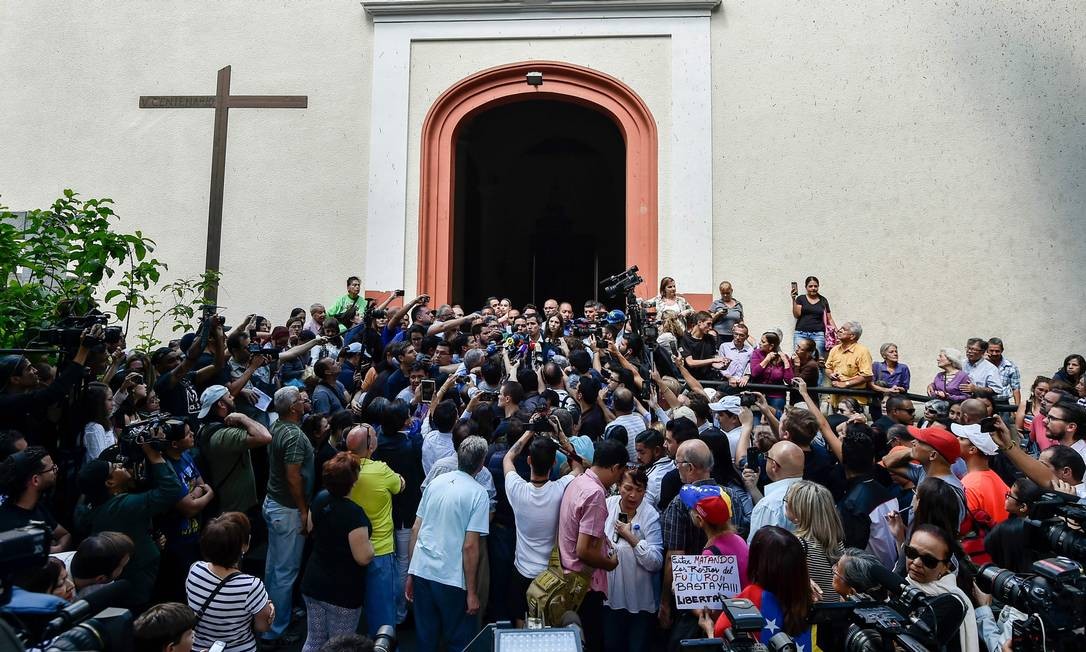 Autoproclamado presidente interino da Venezuela, Juan Guaidó fala a jornalistas e fãs na porta de igreja em Chacao, em Caracas Foto: LUIS ROBAYO / AFP