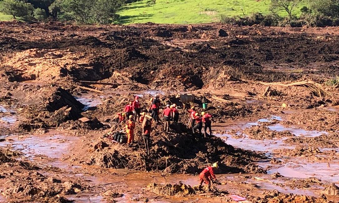 Bombeiros trabalham no resgate de corpos de veículo soterrado pela lama Foto: Márcia Foletto / Agência O Globo