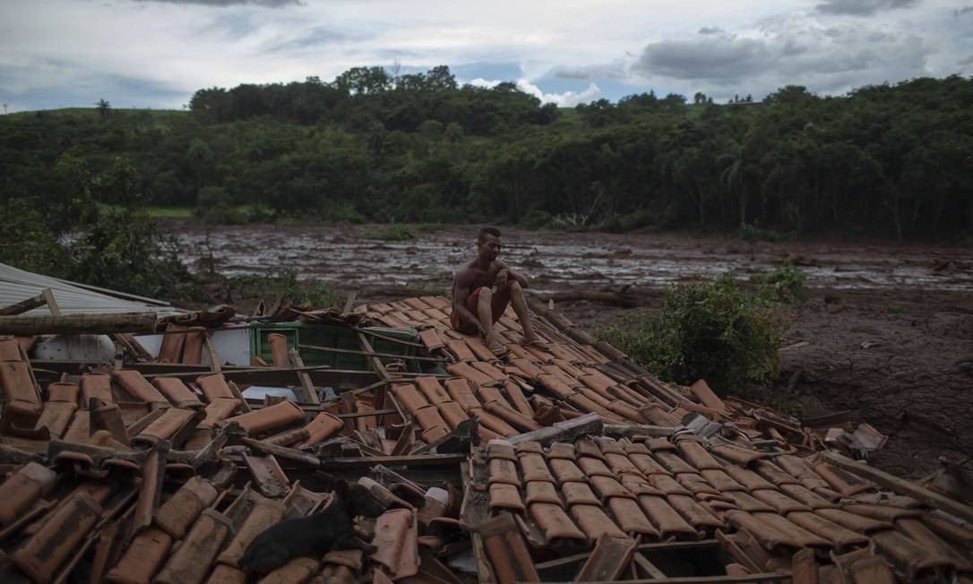 "Tudo tremeu. Vi árvores gigantes e pessoas desaparecendo sob a lama", conta Emerson dos Santos, sentado sobre o telhado de sua casa para proteger o que sobrou de saqueadores. Mauro Pimentel / AFP