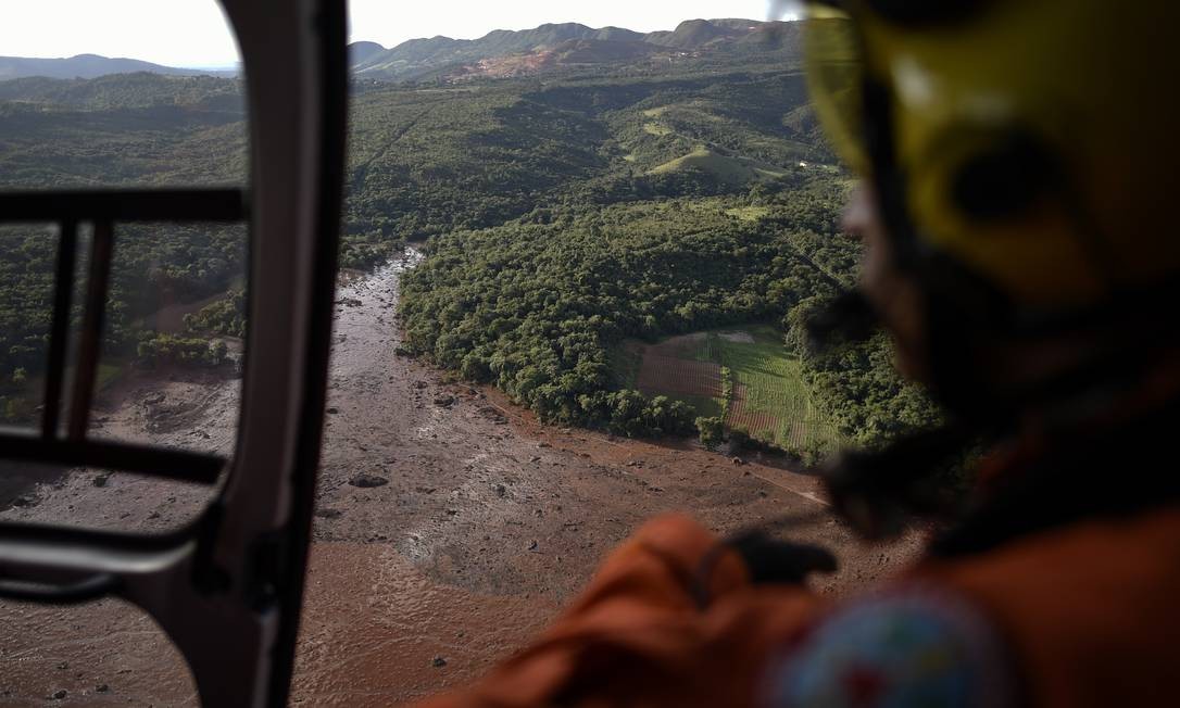 Bombeiros usaram helicopteros para auxiliar na busca de sobreviventes no local. A barragem de Brumadinho era de propriedade da Vale, a maior empresa de mineração do Brasil Douglas Magno / AFP