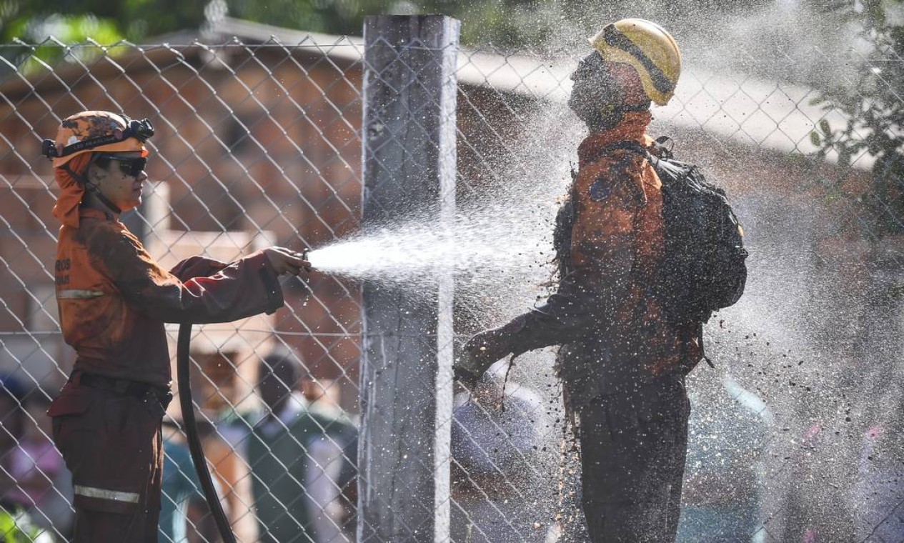 Bombeiros se limpam após tentativas de resgate na área devastada Foto: Pedro Vilela / Getty Images