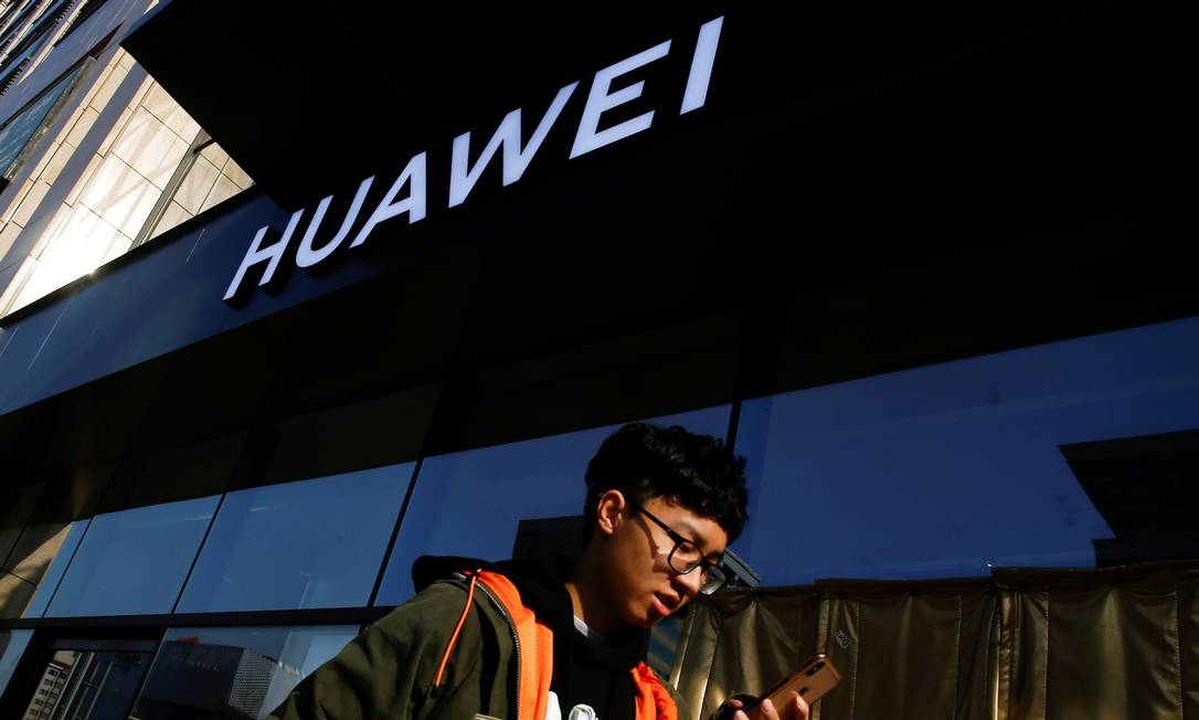 Homem passa por loja da Huawei em Pequim: processos nos EUA Foto: Thomas Peter / REUTERS