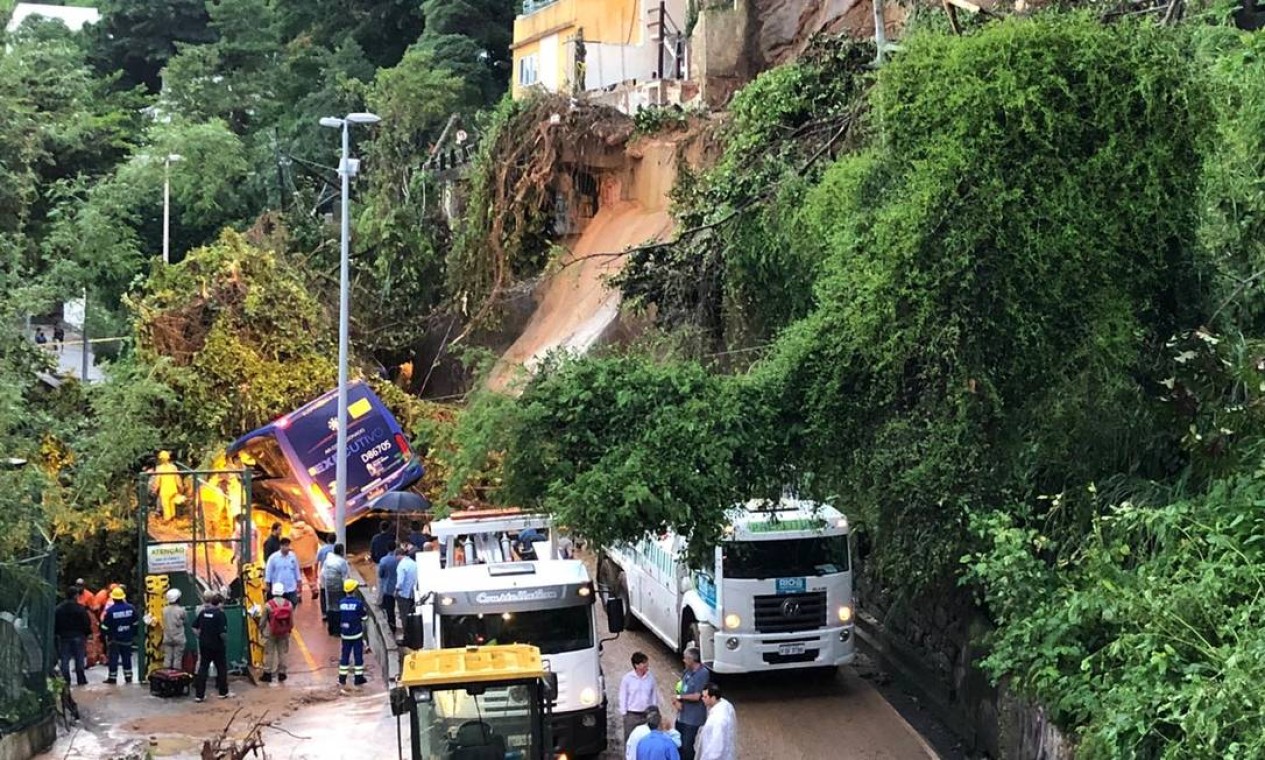 Ônibus ficou parcialmente soterrado com o deslizamento de parte da encosta do Morro do Vidigal, na Avenida Niemeyer. Segundo relato do motorista, duas pessoas ficaram presas dentro do veículo Foto: AOG