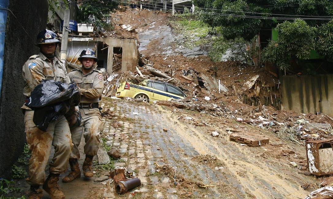 Bombeiros retiram corpo no Morro dos Prazeres, após deslizamento provocado por temporal em abril de 2010 Foto: André Teixeira / Agência O Globo/07-04-2010