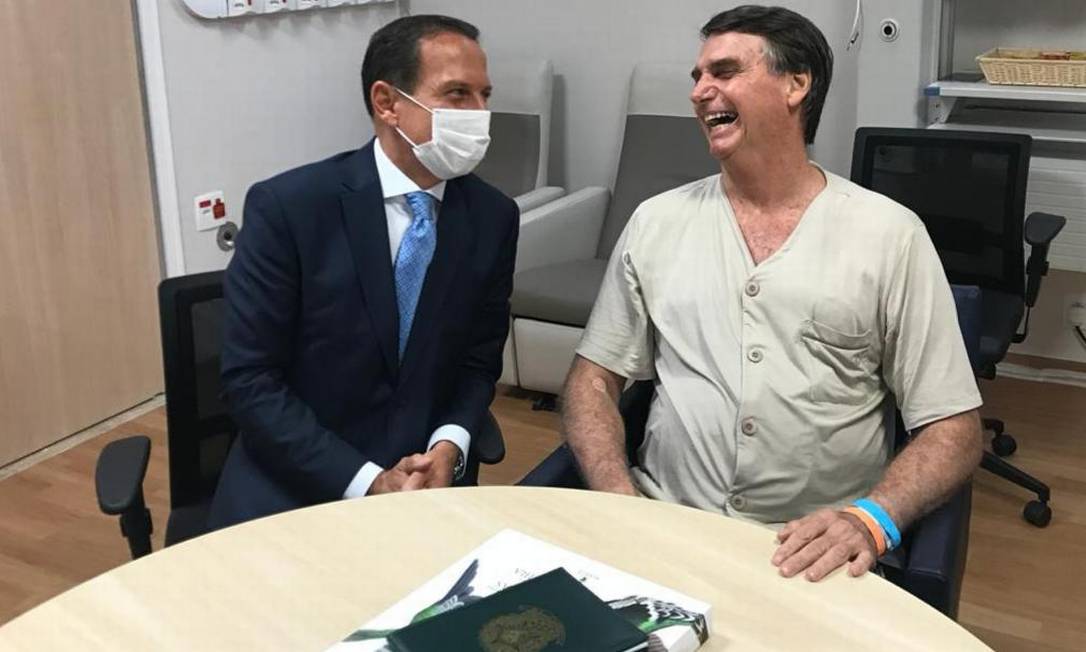 Doria, de máscara, visita o presidente Jair Bolsonaro no hospital e fala com ele sobre Previdência Foto: Divulgação