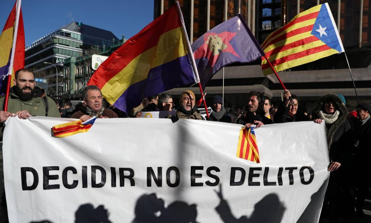 Manifestantes exibem bandeiras catalãs e republicanas espanholas durante protesto em frente ao Tribunal Supremo, em Madri, e uma faixa em que se lê: "Decidir não é crime", em referência ao referendo separatista considerado ilegal pelo governo central Foto: SUSANA VERA / REUTERS