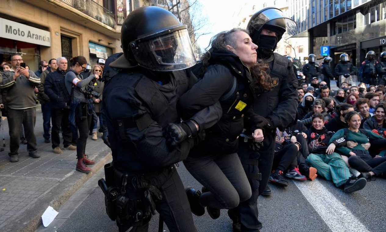 Forças policiais tentam dispersar estudantes que bloqueiam uma rua em Barcelona para protestar contra o julgamento dos separatistas Foto: LLUIS GENE / AFP