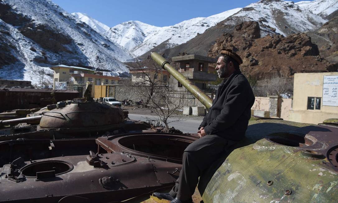 Homem afegão sentado nos restos de tanques da era soviética Foto: WAKIL KOHSAR / AFP