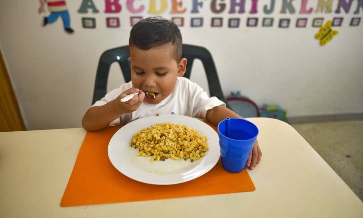 O pequeno Jaiser Rodríguez, 5 anos, come no abrigo da Fundação Kapuy – onde recebeu tratamento para desnutrição Foto: YURI CORTEZ / AFP