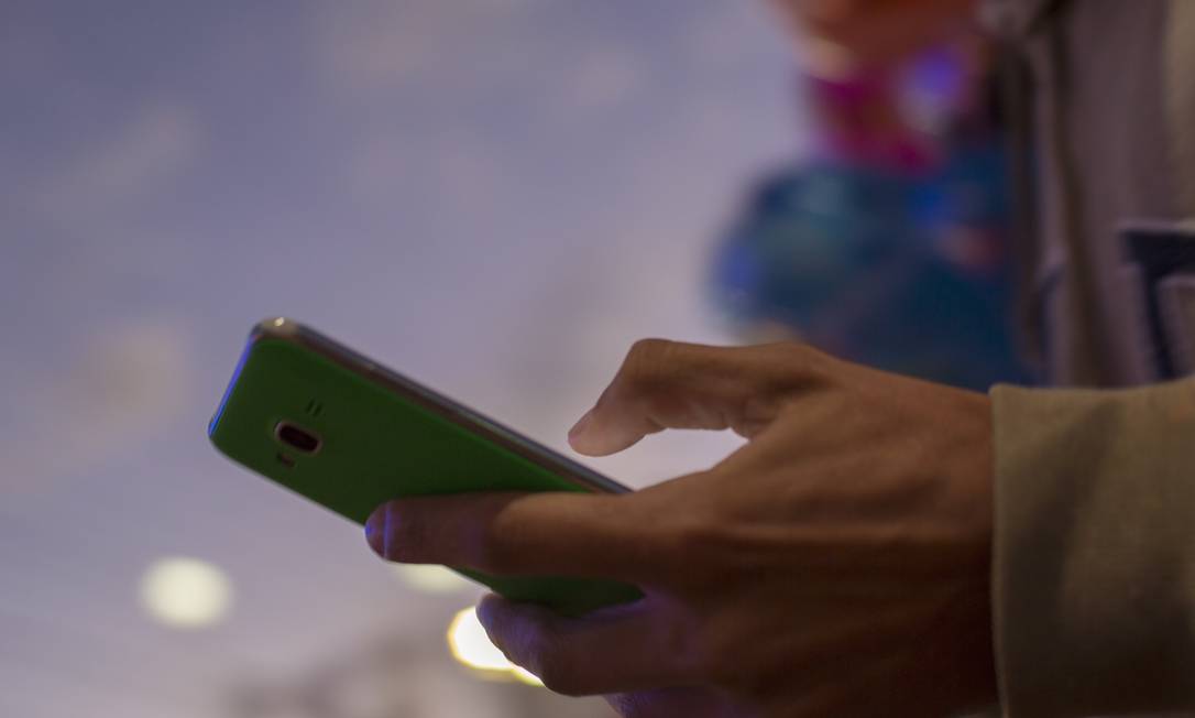 Jovem usando celular: buscas no Google sobre "como fazer o currículo pelo celular saltaram 270% em cinco anos" Foto: Daniel Marenco / Agência O Globo