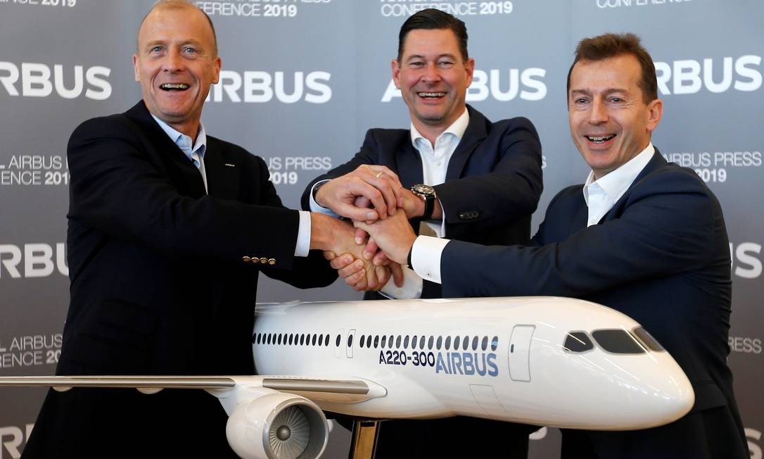 Da esquerda para direita, o presidente-executivo da Airbus, Tom Enders; Guillaume Faury, presidente da Airbus Commercial Aircraft; e o diretor financeiro da Airbus, Harald Wilhelm, posam com uma réplica do Airbus A220-300 durante a conferência de imprensa onde anunciaram os resultados da empresa em 2018 Foto: REGIS DUVIGNAU / REUTERS