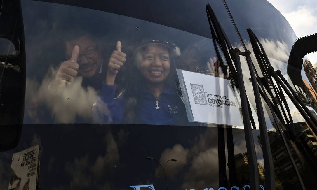 Opositores acenam de ônibus que viajam de Caracas à fronteira venezuelana com a Colômbia Foto: YURI CORTEZ / AFP