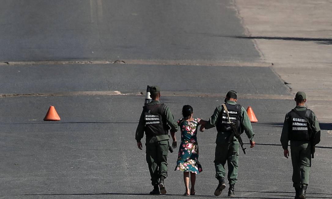 Soldados venezuelanos levam mulher que tentava cruzar fronteira em Pacaraima Foto: RICARDO MORAES / REUTERS