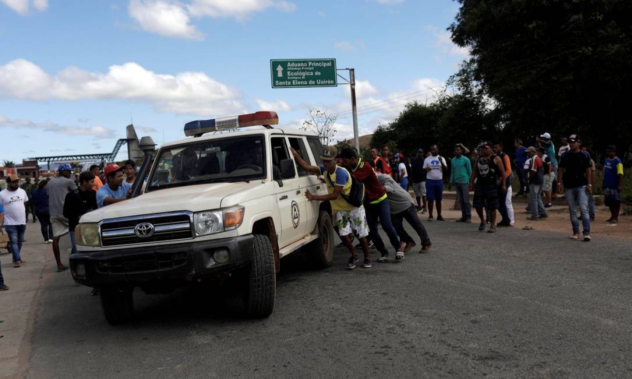 Uma ambulância que transportava pessoas feridas durante confrontos no sul da cidade venezuelana de Kumarakapai, perto da fronteira com o Brasil, é assistida por pessoas na fronteira. Feridos foram levados para Roraima Foto: RICARDO MORAES / REUTERS