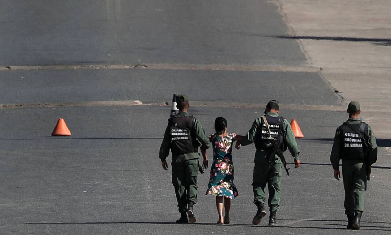 Soldados venezuelanos conduzem uma mulher pelo braço na fronteira entre a Venezuela e o Brasil, em Pacaraima (RR) Foto: RICARDO MORAES / REUTERS