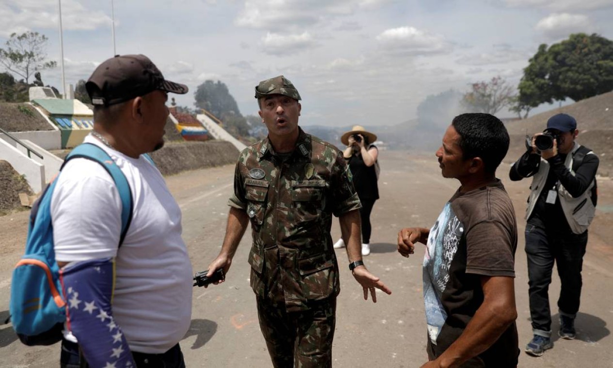 O coronel brasileiro George Feres Canaã pede aos manifestantes que parem de atirar objetos nos militares venezuelanos Foto: RICARDO MORAES / REUTERS