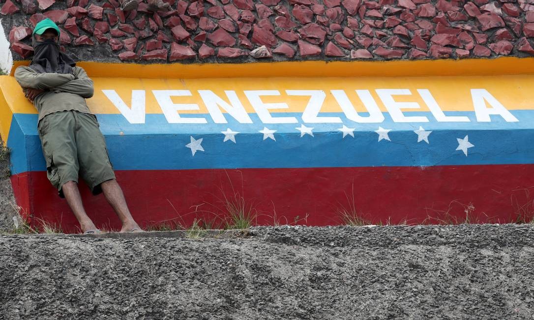 Manifestantes contra governo de Nicolás Maduro se senta sobre a divisa entre Brasil e Venezuela; em dois dias, seis pessoas morreram em confrontos com militares venezuelanos Foto: RICARDO MORAES / REUTERS