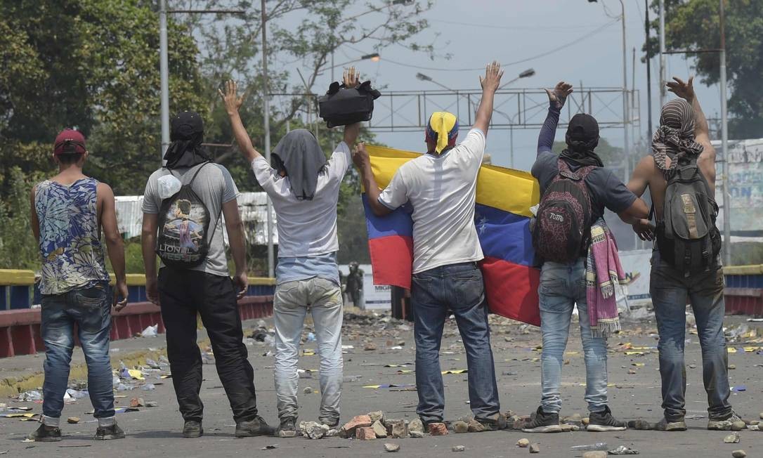 Pequeno grupo de manifestantes em provocações a agentes militares venezuelanos na ponte internacional Francisco de Paula Santander , uma das que conectam Venezuela e Colômbia Foto: RAUL ARBOLEDA / AFP