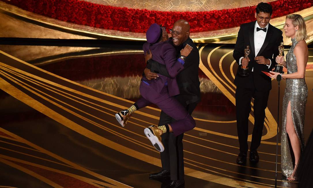 Spike Lee pula no pescoço do ator Samuel L. Jackson ao aceitar o Oscar de melhor roteiro adaptado por 'Infiltrado na Klan' Foto: VALERIE MACON / AFP