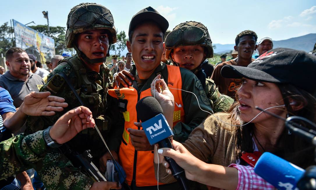 Soldados colombianos escoltam membro das Forças Armadas que desertou para a Colômbia Foto: LUIS ROBAYO / AFP