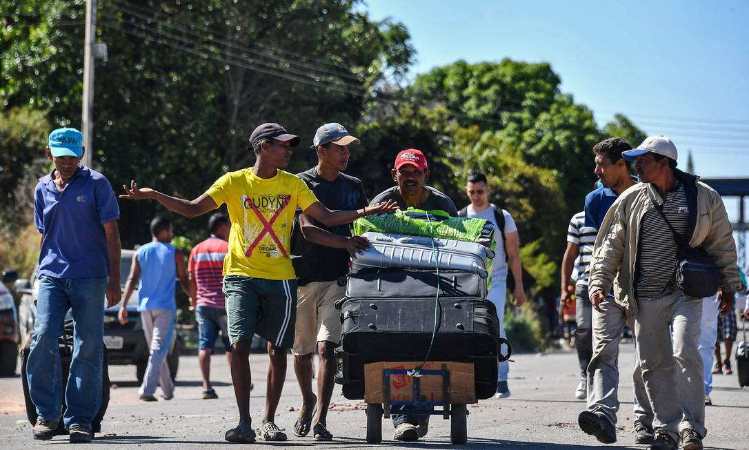 Pessoas cruzam fronteira da Venezuela com o Brasil em busca de refúgio. Centenas de brasileiros estavam detidos em Santa Elena de Uairen Foto: NELSON ALMEIDA / AFP