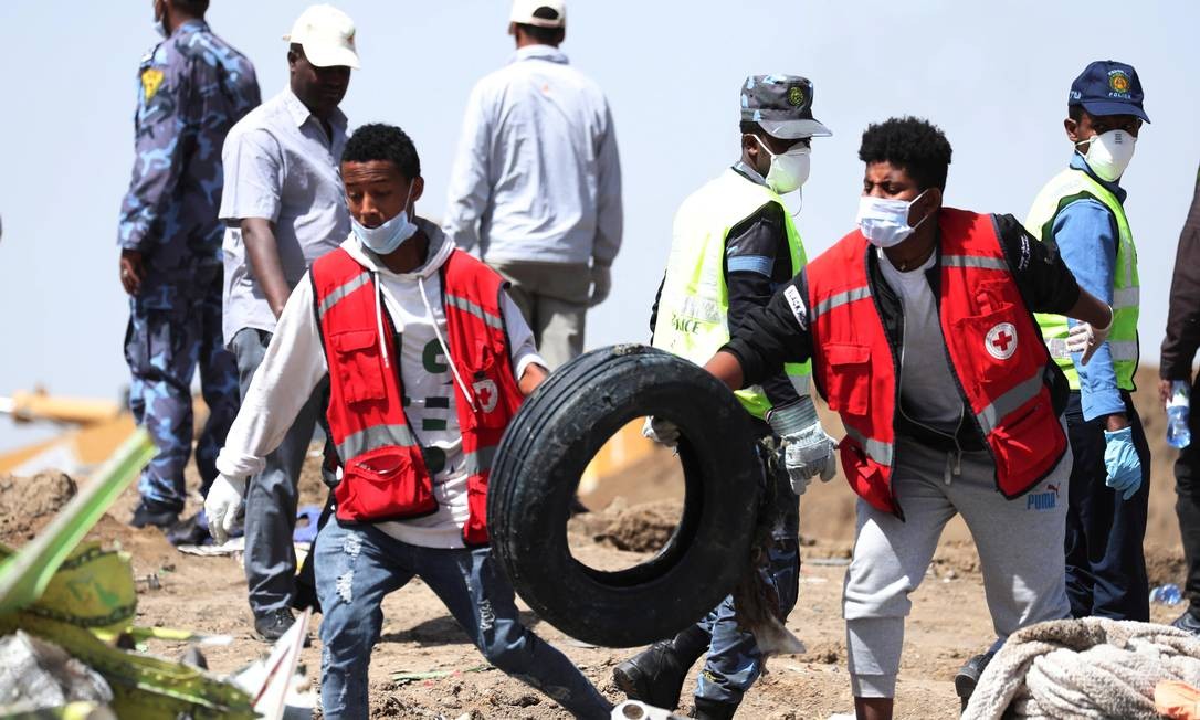 Socorristas carregam pneu após queda de avião na Etiópia que matou 157 a bordo Foto: TIKSA NEGERI / REUTERS