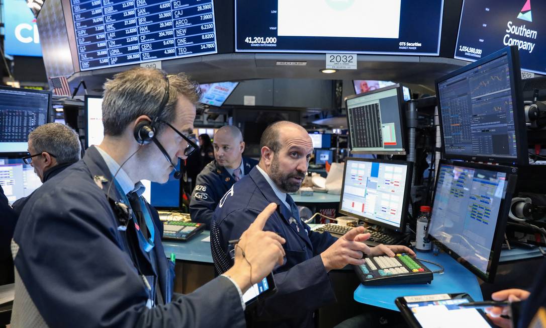 Traders em Wall Street: informar-se antes de investir é essencial. Foto: BRENDAN MCDERMID / REUTERS