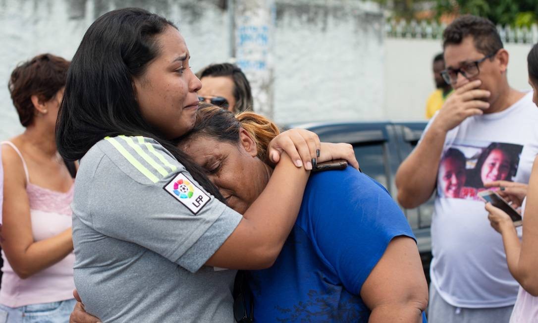 Familiares e amigos de estudantes se consolam em meio ao desespero em frente à Escola Raul Brasil, após atentado Foto: Julien Pereira/Fotoarena / Agência O Globo