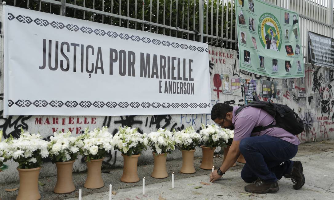 Homem acende vela no lugar onde Marielle e o motorista Anderson Gomes foram executados Foto: Gabriel de Paiva / Agência O Globo