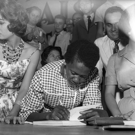 A escritora Carolina Maria de Jesus autografa um de seus livros mais conhecidos, 'Quarto de Despejo' durante o I Festival do Rio. 09-11-1960 Foto: Arquivo / Agência O Globo