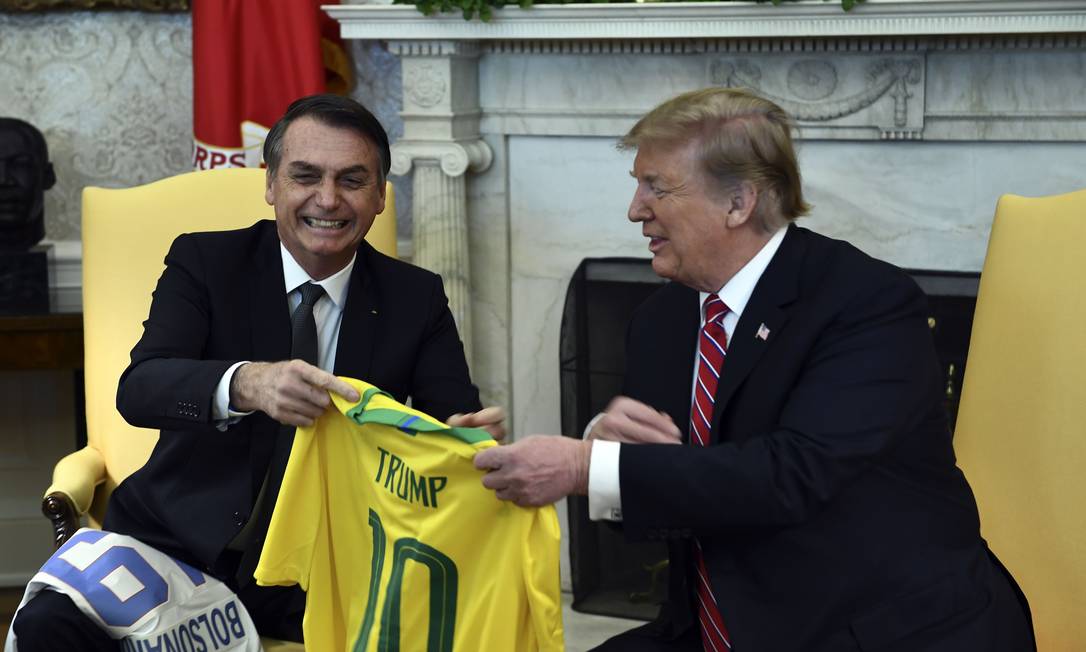 Presidente do Brasil, Jair Bolsonaro, e presidente dos EUA, Donald Trump, trocam presentes no Salão Oval da Casa Branca Foto: BRENDAN SMIALOWSKI / AFP