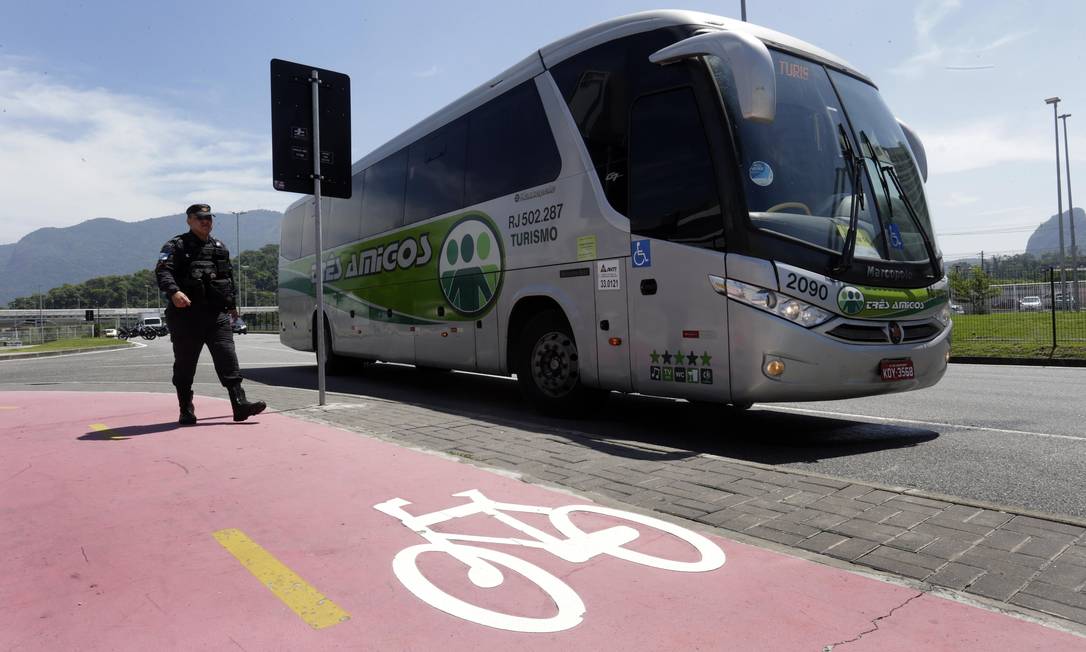 Policial passa ao lado do ônibus que atropelou o ciclista na Barra Foto: Marcio Alves / Agência O Globo