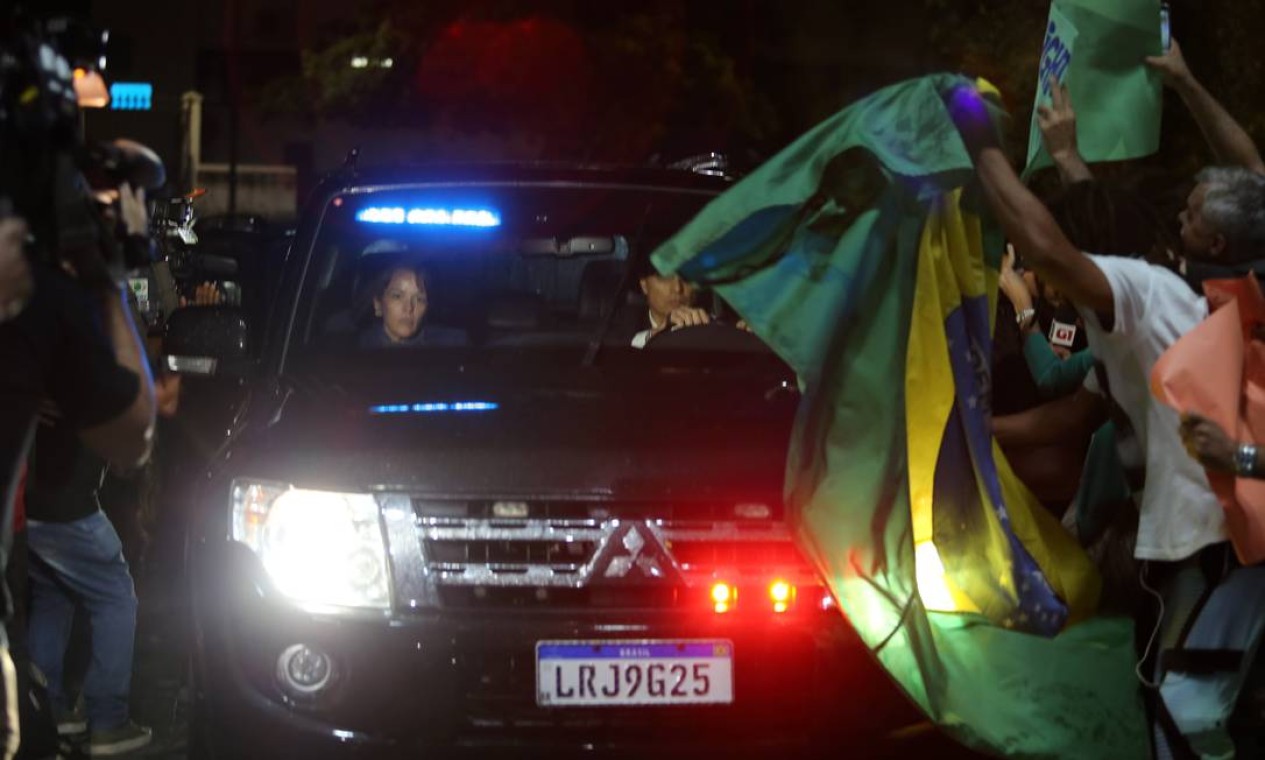 Manifestantes agitam bandeira do Brasil em frente aos carros que levam Michel Temer à sede da PF no Rio Foto: Fabio Guimarães / Agência O Globo