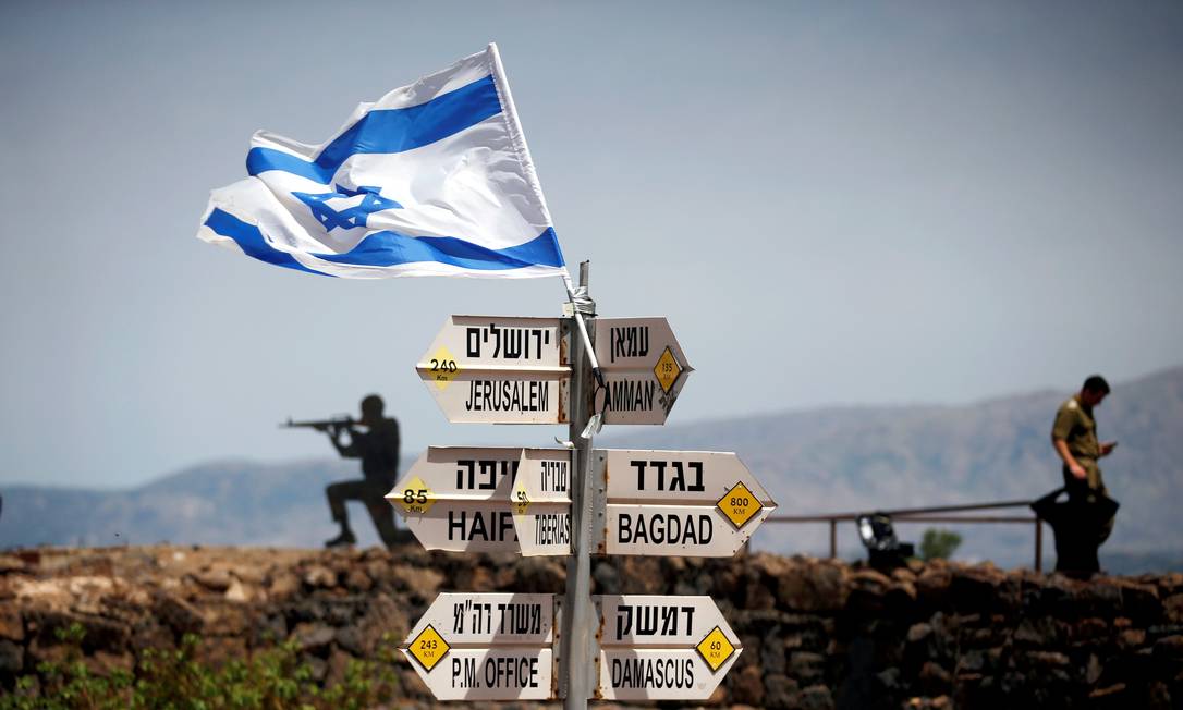 Soldado israelense ao lado de placa que aponta distância para várias cidades a partir das Colinas de Golã Foto: RONEN ZVULUN / REUTERS