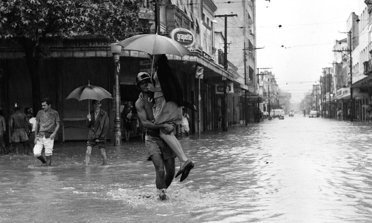 Homem carrega mulher durante enchente na Praça da Bandeira, 1966 Foto: Agência O Globo