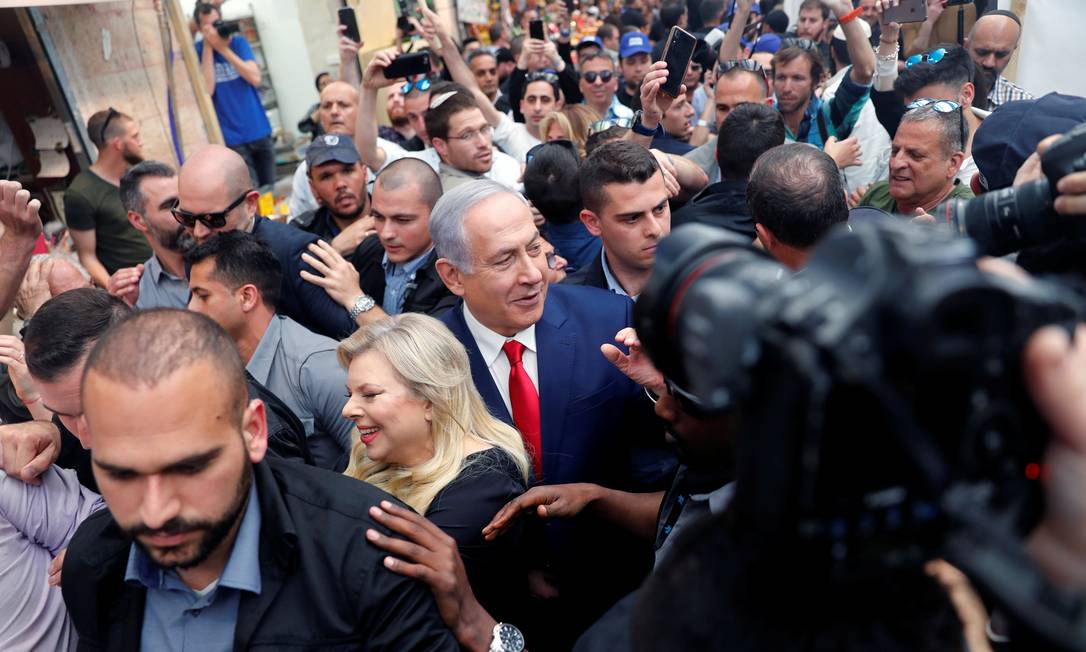 Cercados por seguranças, o primeiro-ministro israelense, Benjamin Netanyahu, e sua mulher, Sara, visitam mercado em Jerusalém Foto: RONEN ZVULUN 08-04-2019 / REUTERS