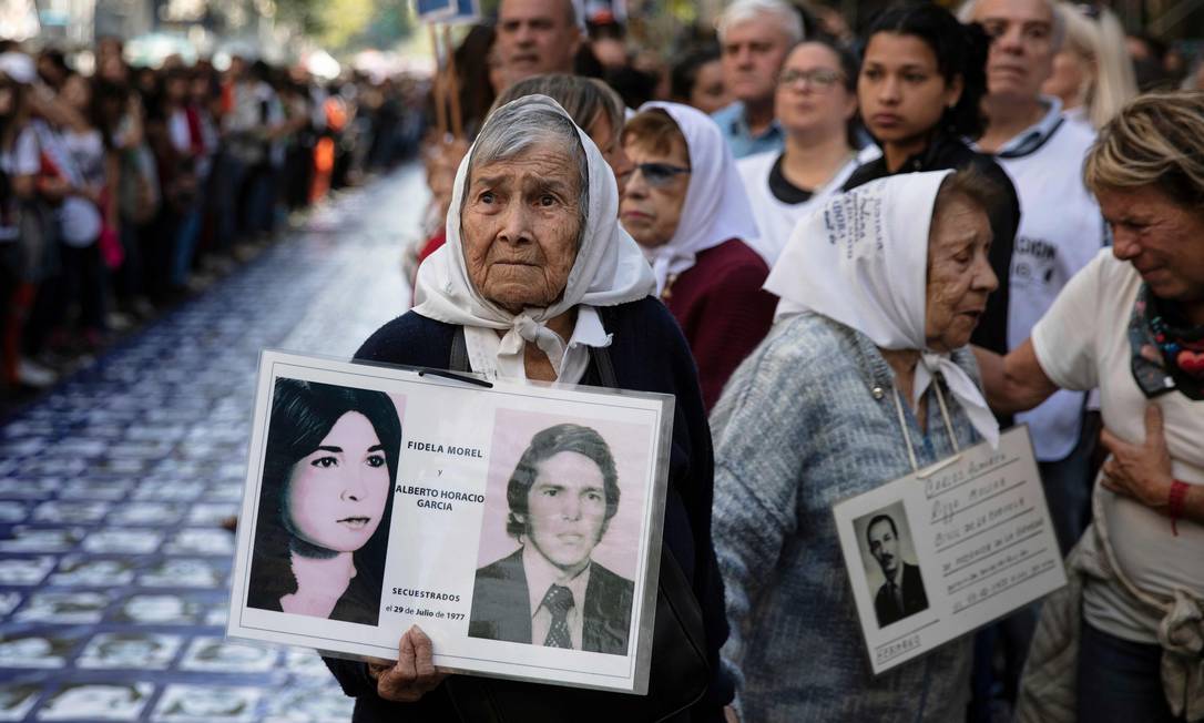 Mães da Praça de Maio seguram fotos de desaparecidos durante a ditadura militar da Argentina Foto: EMILIANO LASALVIA / AFP