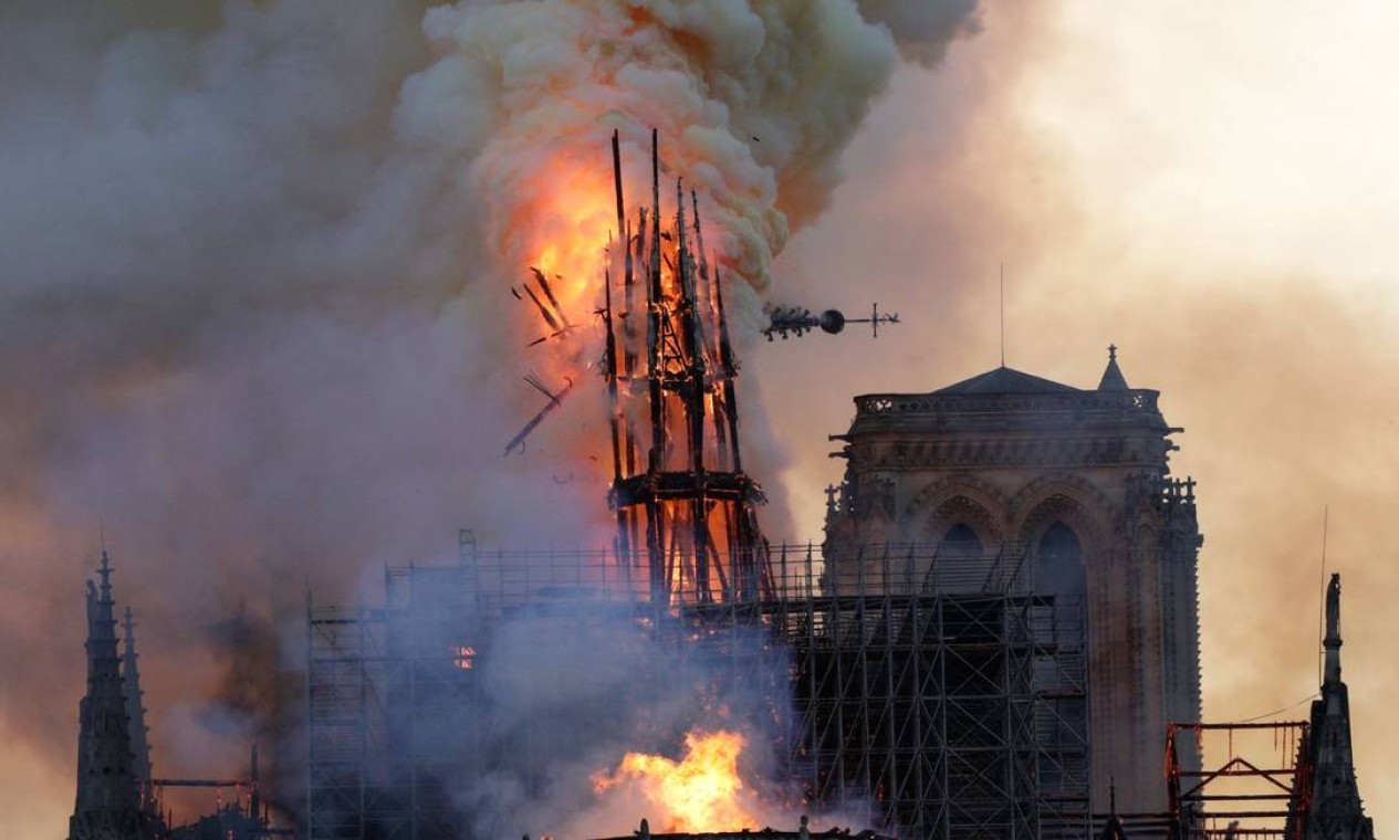 A torre desaba enquanto fumaça e chamas envolvem a Catedral de Notre Dame, no centro de Paris, nesta segunda-feira 15 de abril de 2019 Foto: GEOFFROY VAN DER HASSELT / AFP