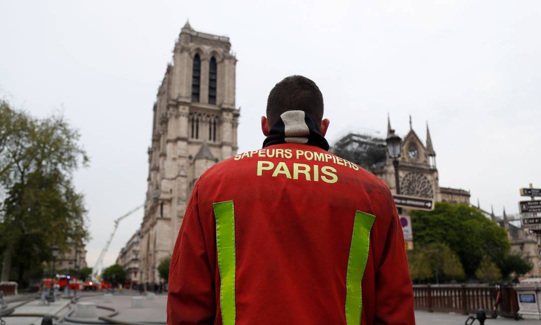 Bombeiro observa catedral de Notre Dame, em Paris, após controle das chamas Foto: ZAKARIA ABDELKAFI 16-04-2019 / AFP