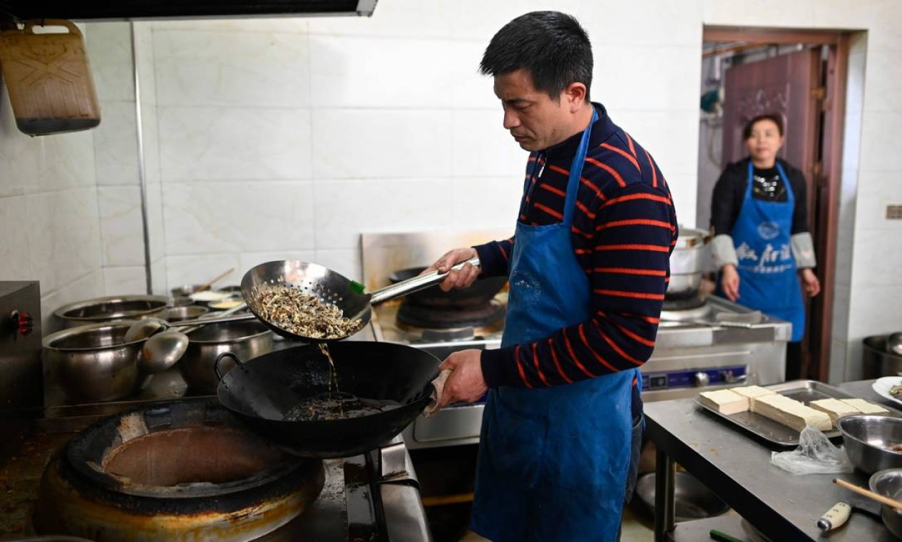 Um cozinheiro frita baratas em um restaurante em Yibin, sudoeste da província de Sichuan Foto: WANG ZHAO / AFP
