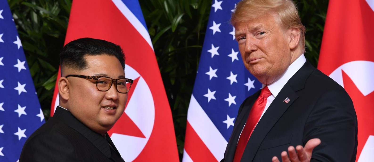 Líder norte-coreano, Kim Jong-un, e presidente dos EUA, Donald Trump, se cumprimentam no seu primeiro encontro frente a frente, realizado em 12 de junho de 2018 e Cingapura Foto: SAUL LOEB / AFP