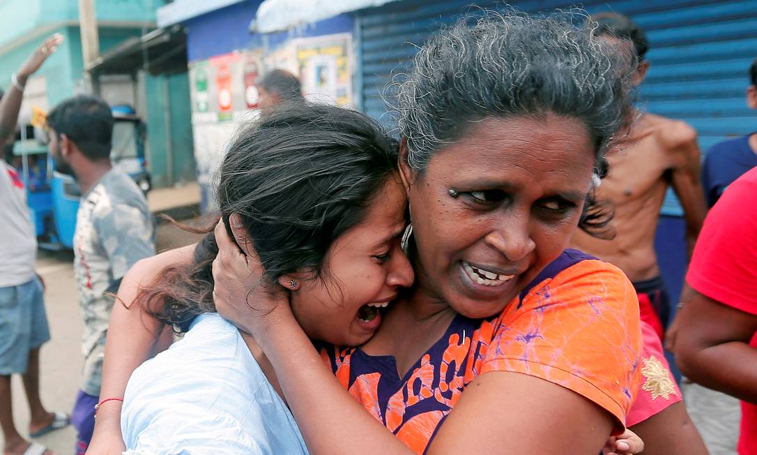 Mulheres que moram perto de igreja atacada no Sri Lanka deixam suas casas durante operação militar em veículo suspeito antes que ele explodisse em Colombo Foto: DINUKA LIYANAWATTE / REUTERS