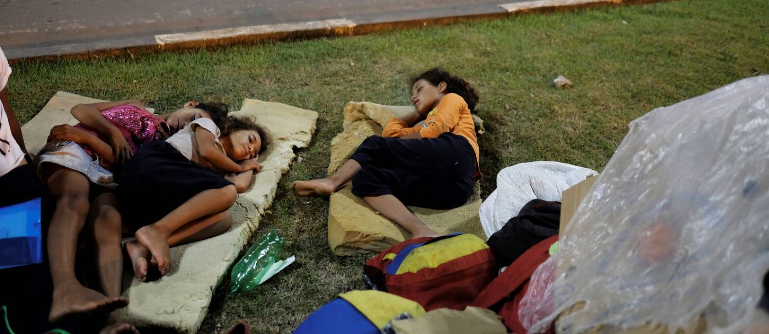 
Crianças venezuelanas dormem à beira de estrada em frente à estação de ônibus de Boa Vista: fluxo de imigrantes pode aumentar com piora da crise, diz prefeita da capital de Roraima
Foto:
NACHO DOCE/Reuters/23-08-2018
