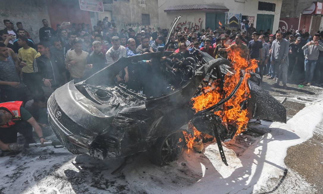 Serviços de emergência palestinos tentam apagar chamas de carro de chefe do Hamas, atingido por bombardeio israelense, em Gaza Foto: MAHMUD HAMS 05-05-2019 / AFP