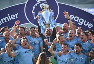 Elenco do Manchester City comemora título, obtido com apenas um ponto de vantagem sobre o Liverpool, segundo colocado Foto: GLYN KIRK / AFP