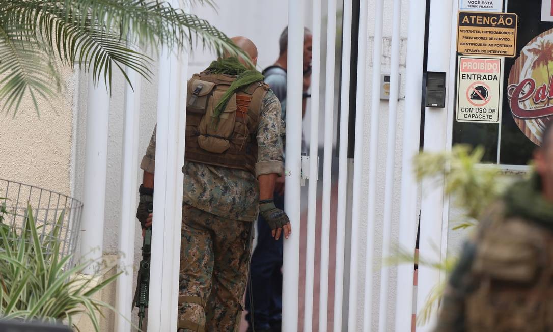 Dois militares durante negociação com homem que mantém mulher e filhos reféns dentro de apartamento em Cascadura Foto: Fabiano Rocha / Agência O Globo