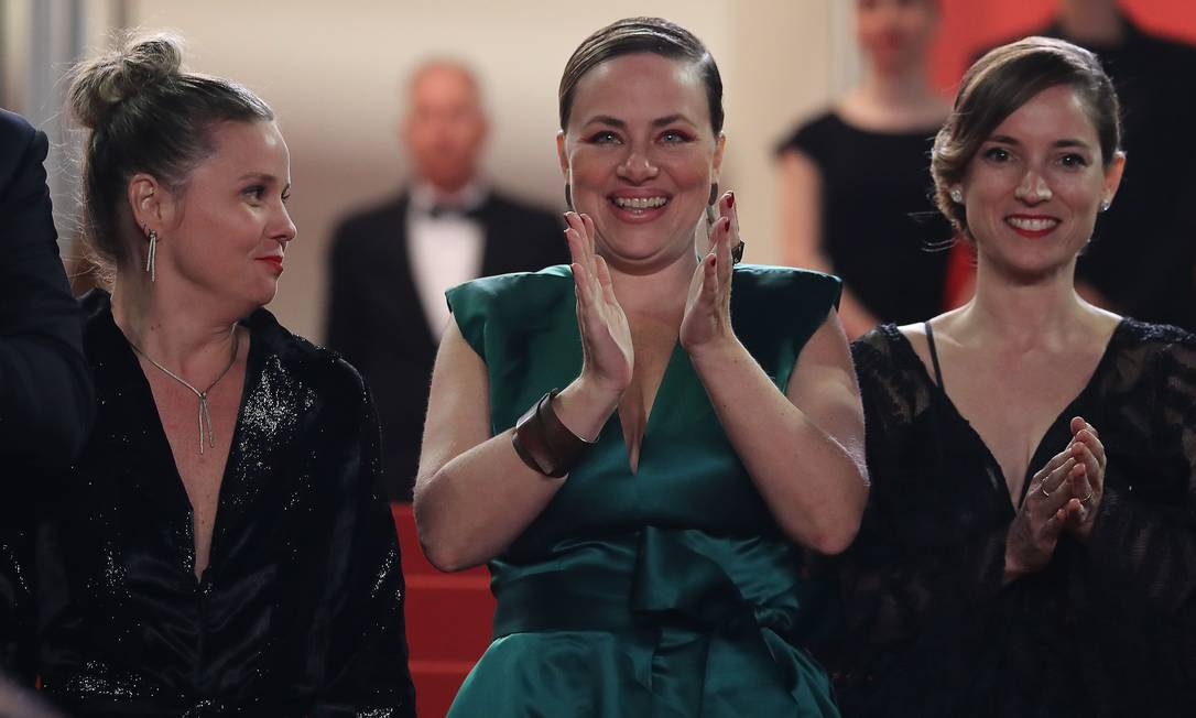 A atriz Karine Teles aplaude, com a produtora francesa Emile Lesclaux ao lado direito Foto: VALERY HACHE / AFP